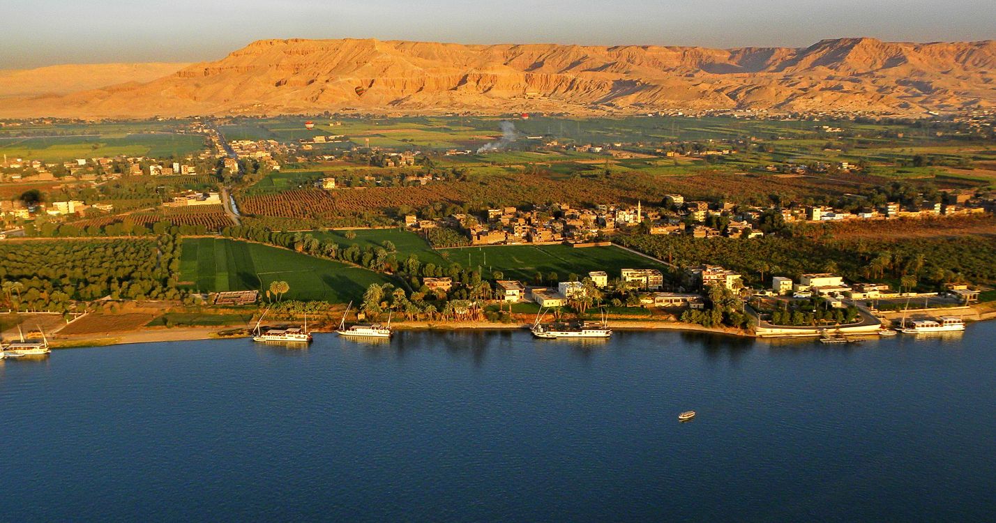 Vista Aérea de Montañas Verdes y Marrones Cerca Del Cuerpo de Agua Durante el Día. Wallpaper in 3216x1689 Resolution