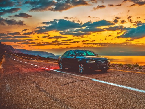 Image black car on road during sunset