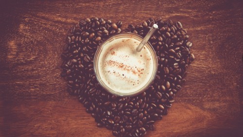 Image white liquid in clear drinking glass on brown coffee beans