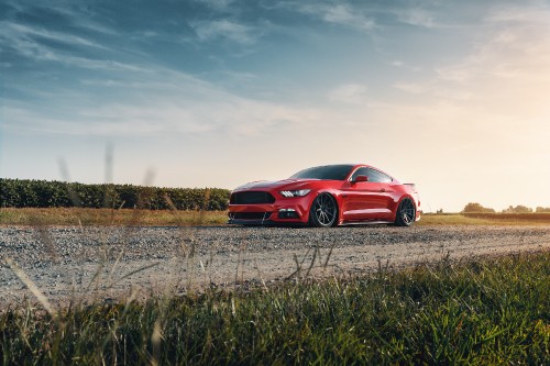 Image red chevrolet camaro on brown grass field under white clouds during daytime