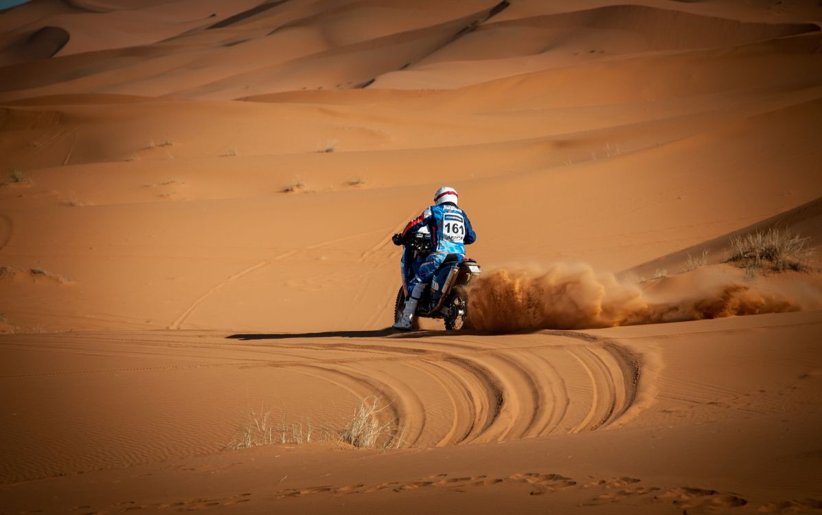 Man Riding Motocross Dirt Bike on Desert During Daytime. Wallpaper in 2047x1282 Resolution