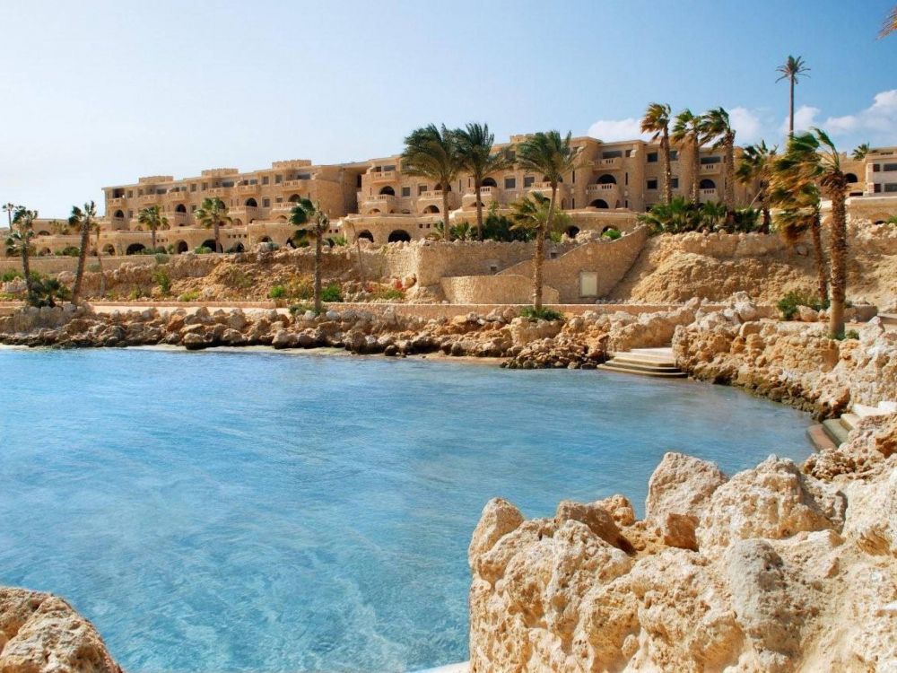 Bâtiment en Béton Brun Près D'un Plan D'eau Pendant la Journée. Wallpaper in 2560x1920 Resolution