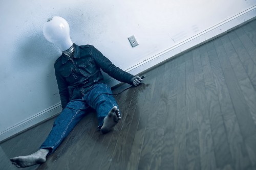 Image man in black leather jacket and blue denim jeans sitting on floor