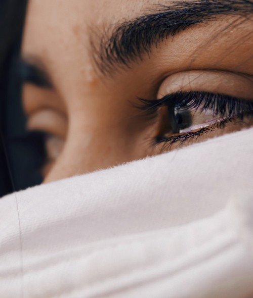 Image woman covering her face with white textile