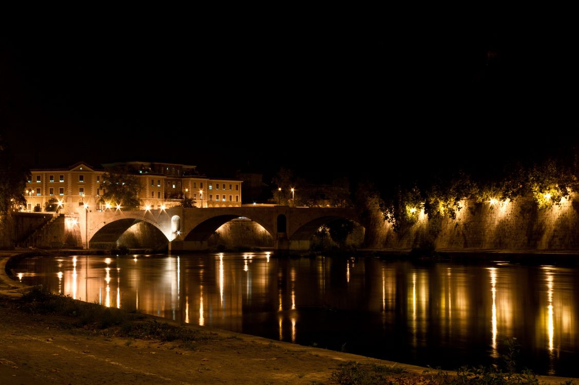 brown concrete building near body of water during night time