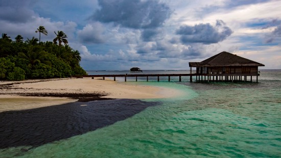 Image brown wooden dock on blue sea under blue sky and white clouds during daytime