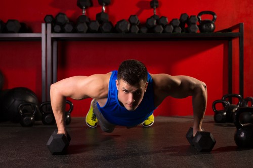 Image man in blue tank top and black shorts doing push up