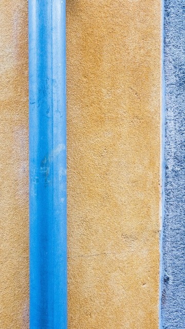 Image blue metal rod on brown concrete wall