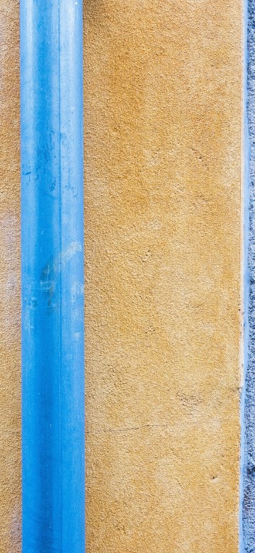 Image blue metal rod on brown concrete wall