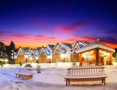 Image white and brown wooden house on snow covered ground during sunset