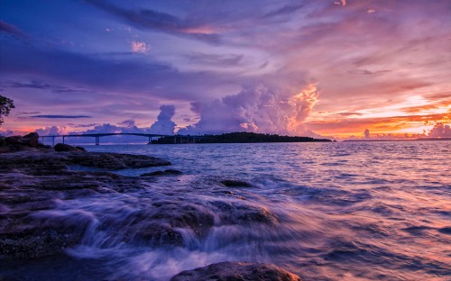 Image ocean waves crashing on shore during sunset