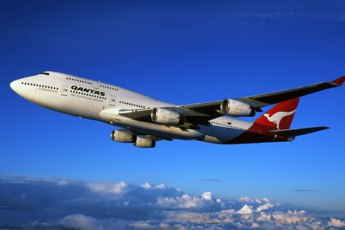 Image white and red airplane in mid air during daytime