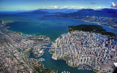 Image aerial view of city buildings near body of water during daytime