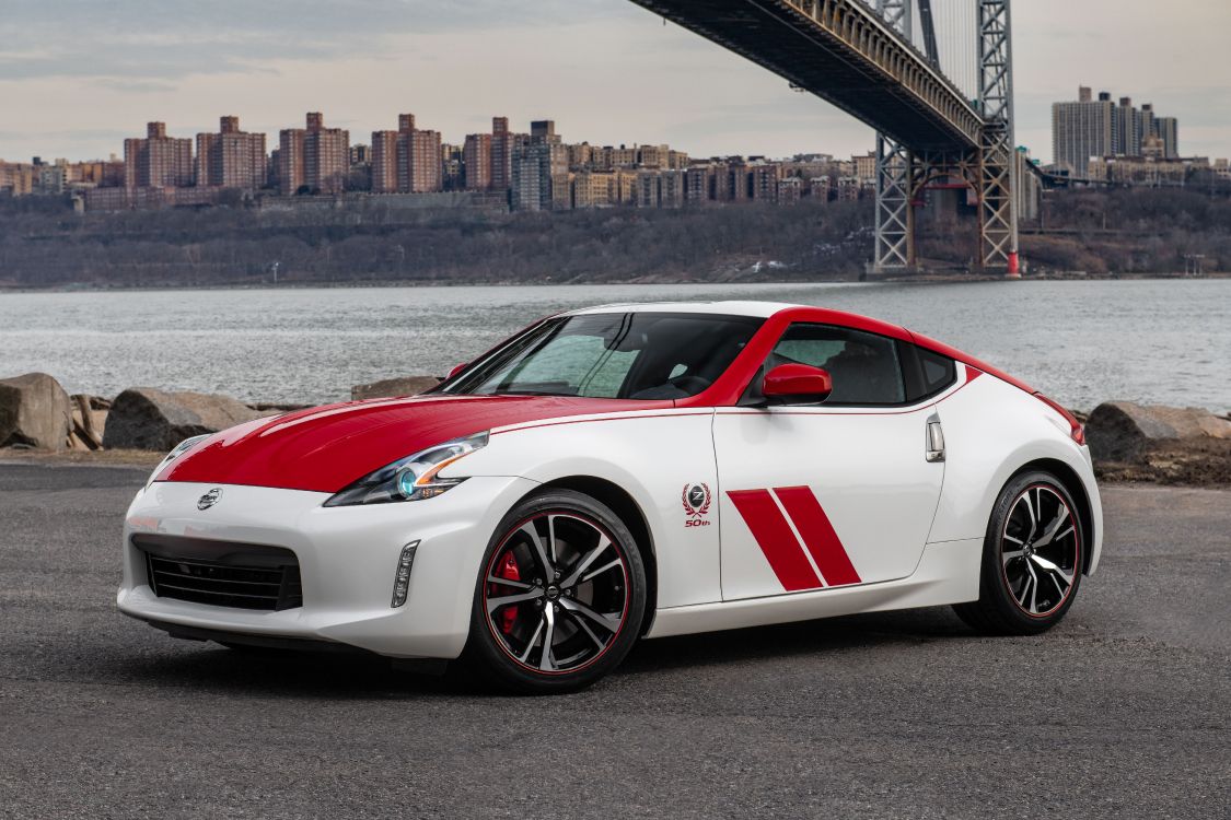 white and red porsche 911 parked on gray pavement near body of water during daytime