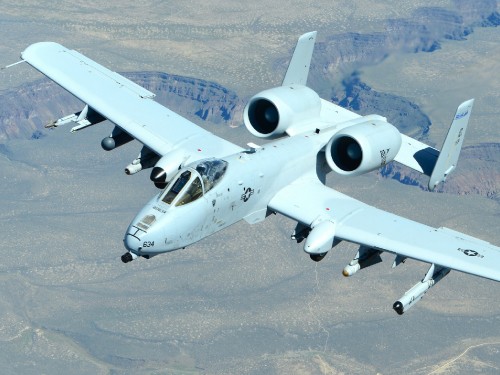 Image white and blue airplane on gray sand during daytime