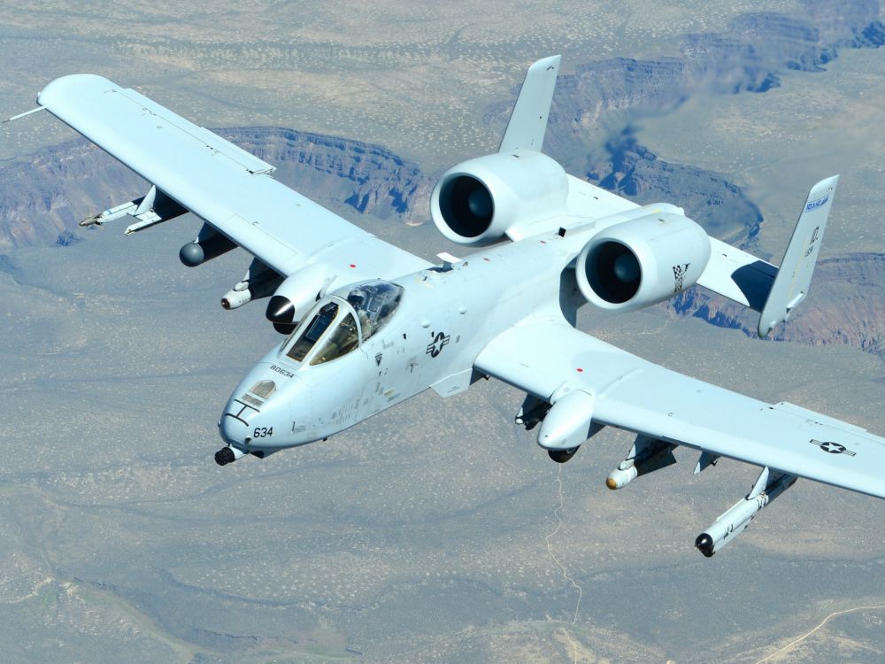 white and blue airplane on gray sand during daytime