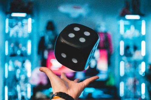 Image person holding purple and white polka dot dice