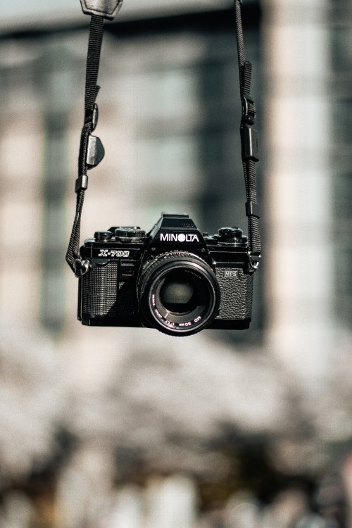 Image black nikon dslr camera hanging on black metal wire