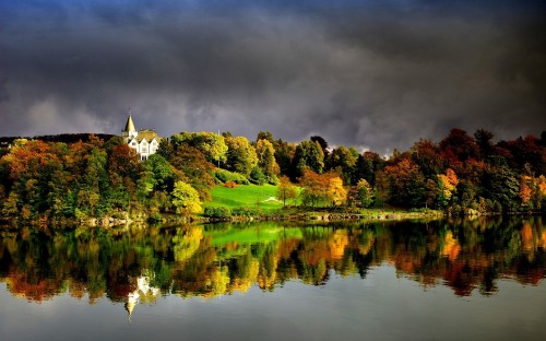 Image green trees beside lake under gray clouds