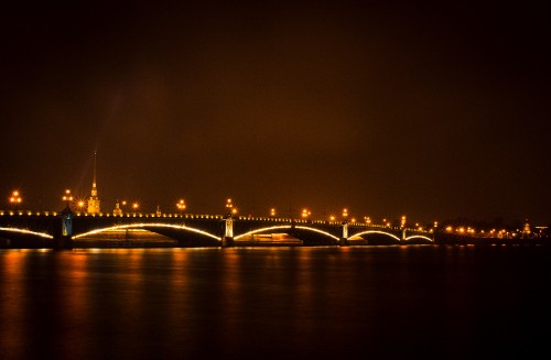 Image lighted bridge over body of water during night time