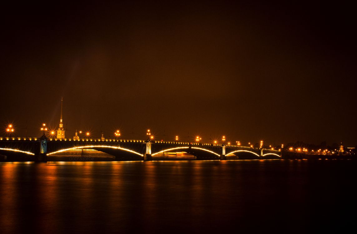 Pont Éclairé Au-dessus D'un Plan D'eau Pendant la Nuit. Wallpaper in 3400x2230 Resolution