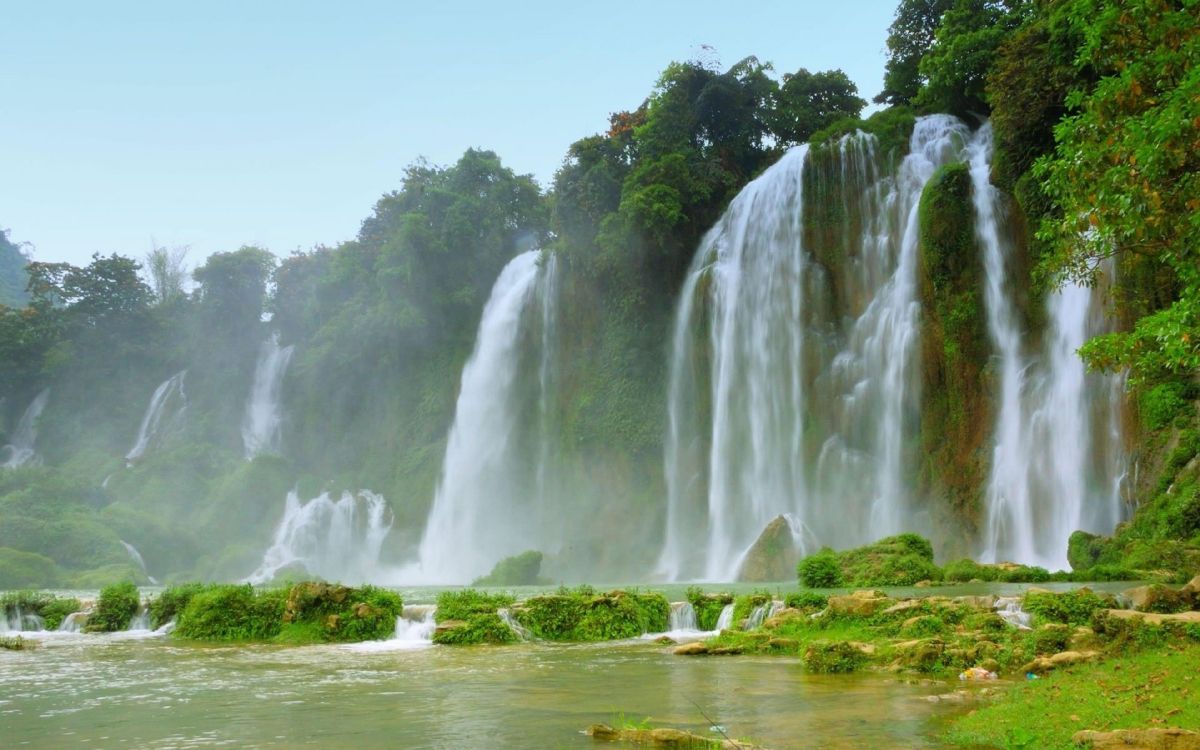 waterfalls on green grass field during daytime