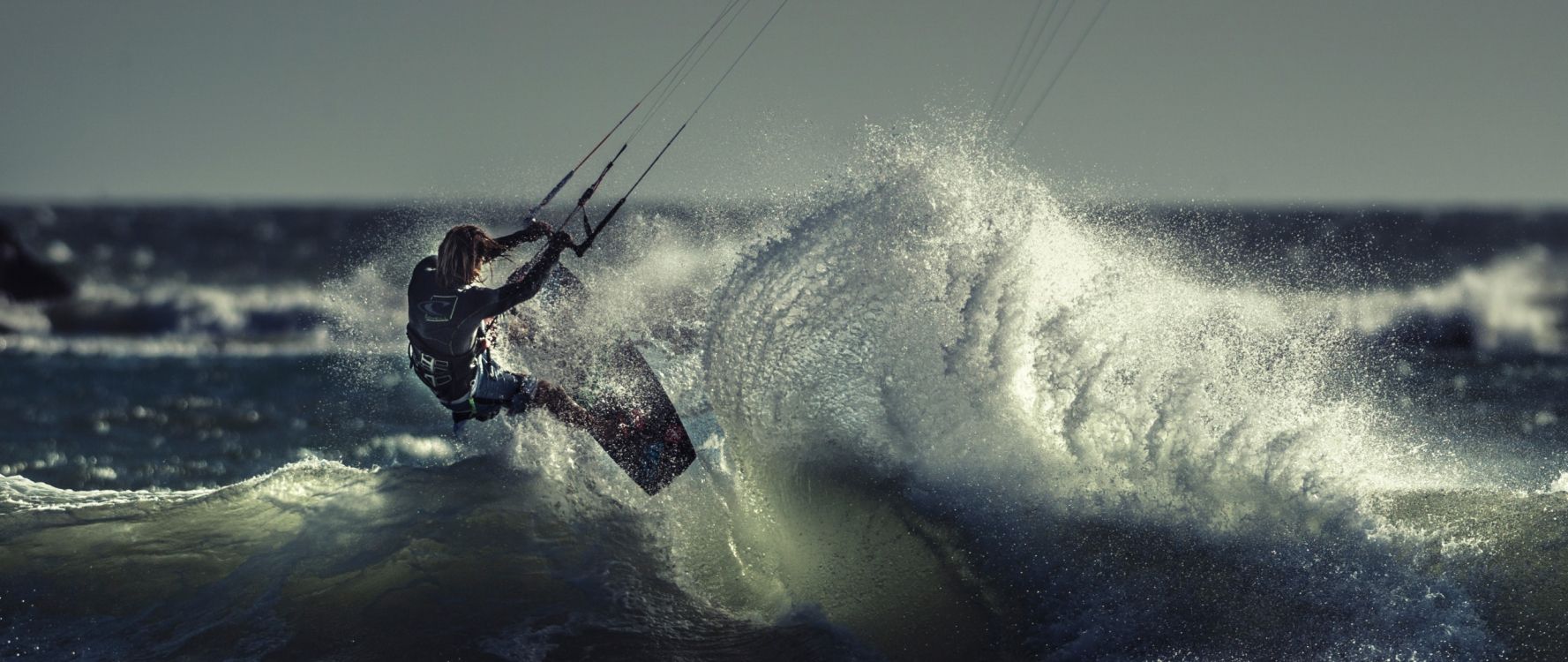 Hombre en Shorts Negros Surfeando Sobre Las Olas Del Agua Durante el Día. Wallpaper in 2560x1080 Resolution