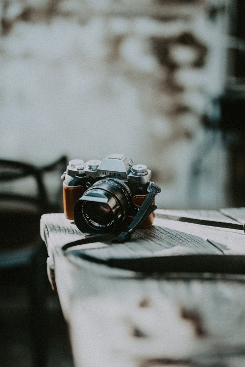 Image black and silver dslr camera on white textile