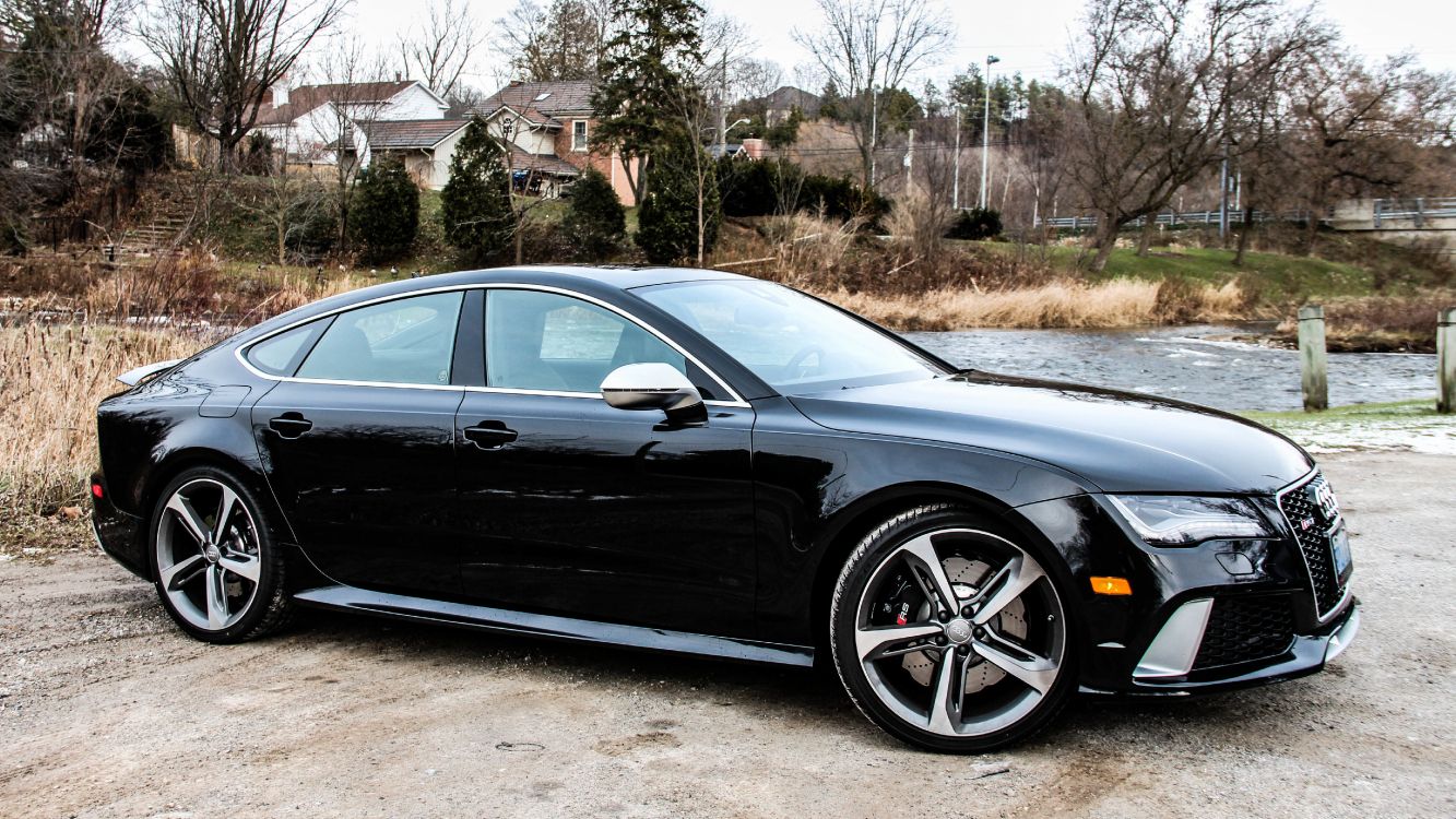 black sedan parked on gray concrete road during daytime