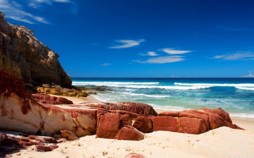 Image brown rock formation near sea under blue sky during daytime