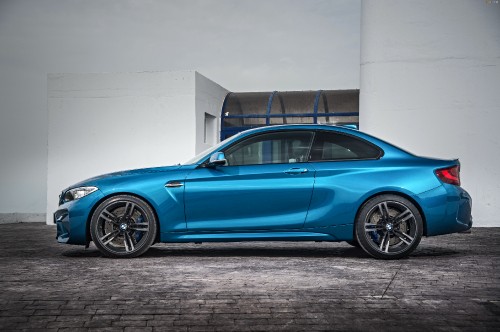 Image blue sedan parked beside white wall