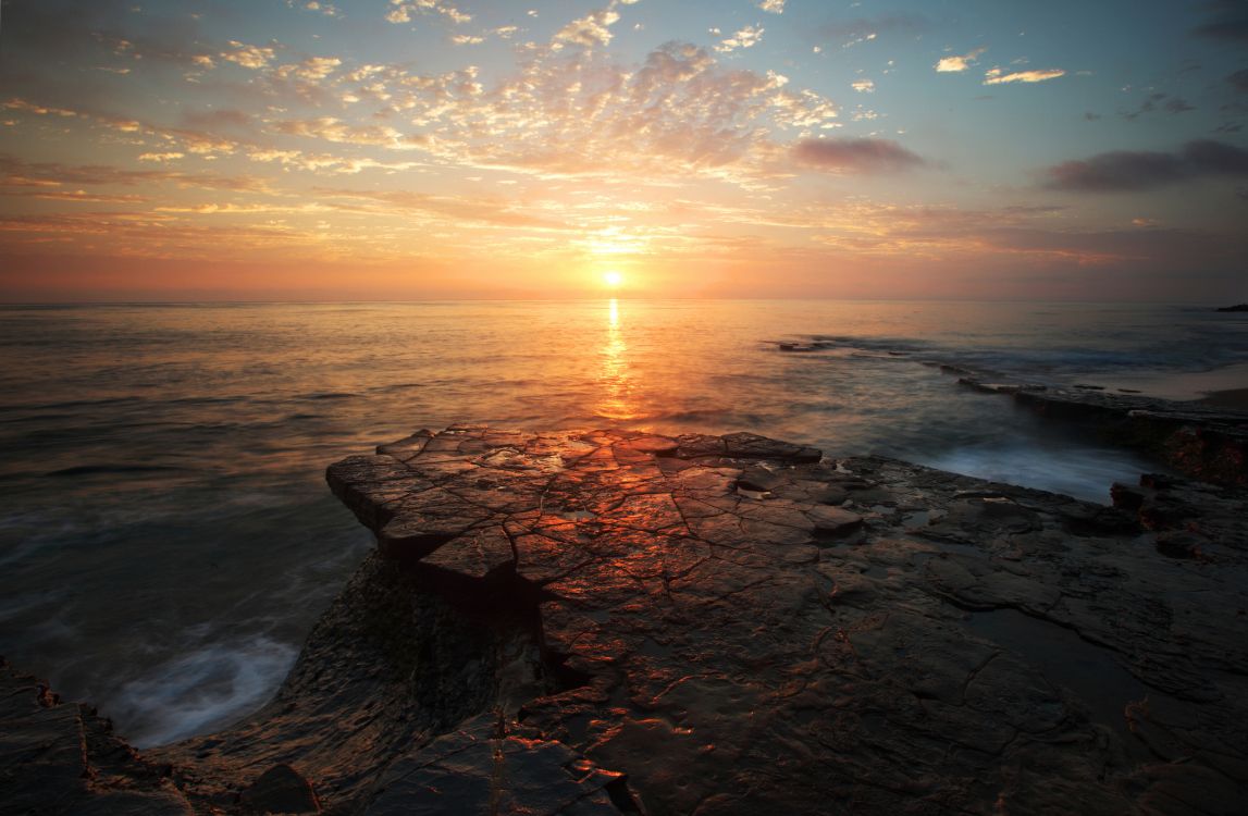 Felsiges Ufer Bei Sonnenuntergang Unter Blauem Himmel. Wallpaper in 2048x1339 Resolution