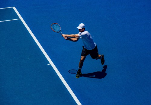 Image man in white shirt and black shorts playing tennis