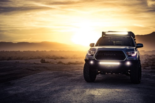 Image black nissan suv on brown sand during sunset