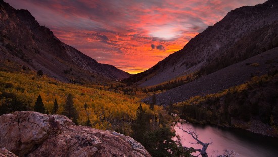 Image lake in the middle of mountains during sunset