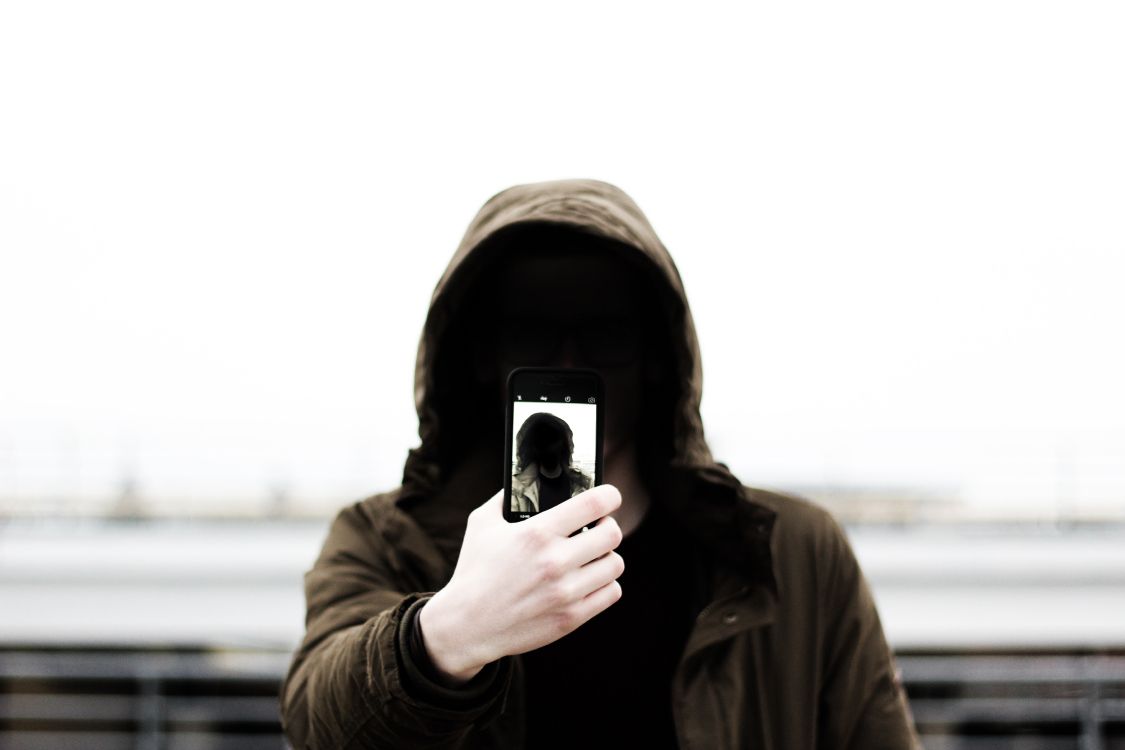 Grayscale Photo of Man in Hoodie Holding Phone. Wallpaper in 5184x3456 Resolution