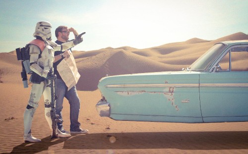 Image man in white jacket and blue denim jeans standing beside blue and white car during daytime