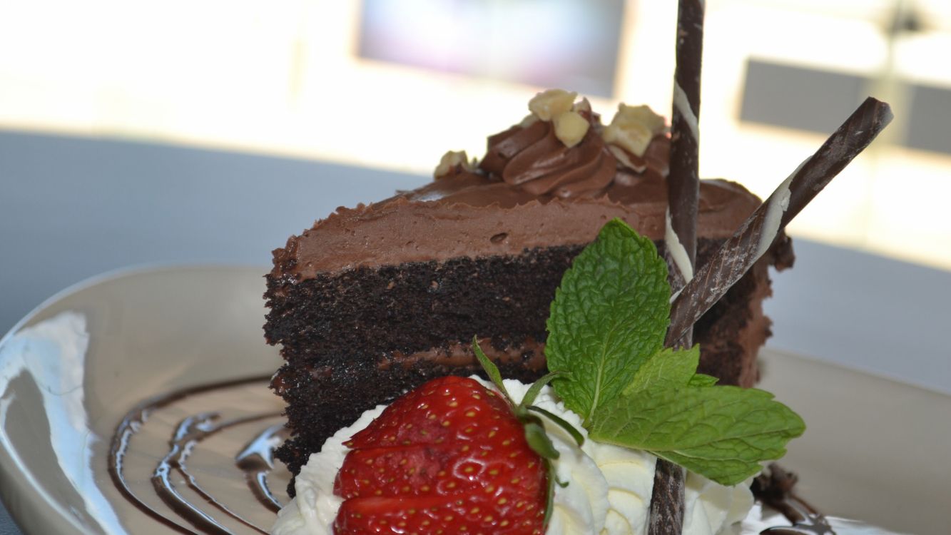 chocolate cake with strawberry on white ceramic plate