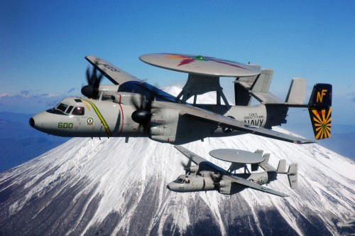 Image gray and black fighter plane flying over snow covered mountain during daytime