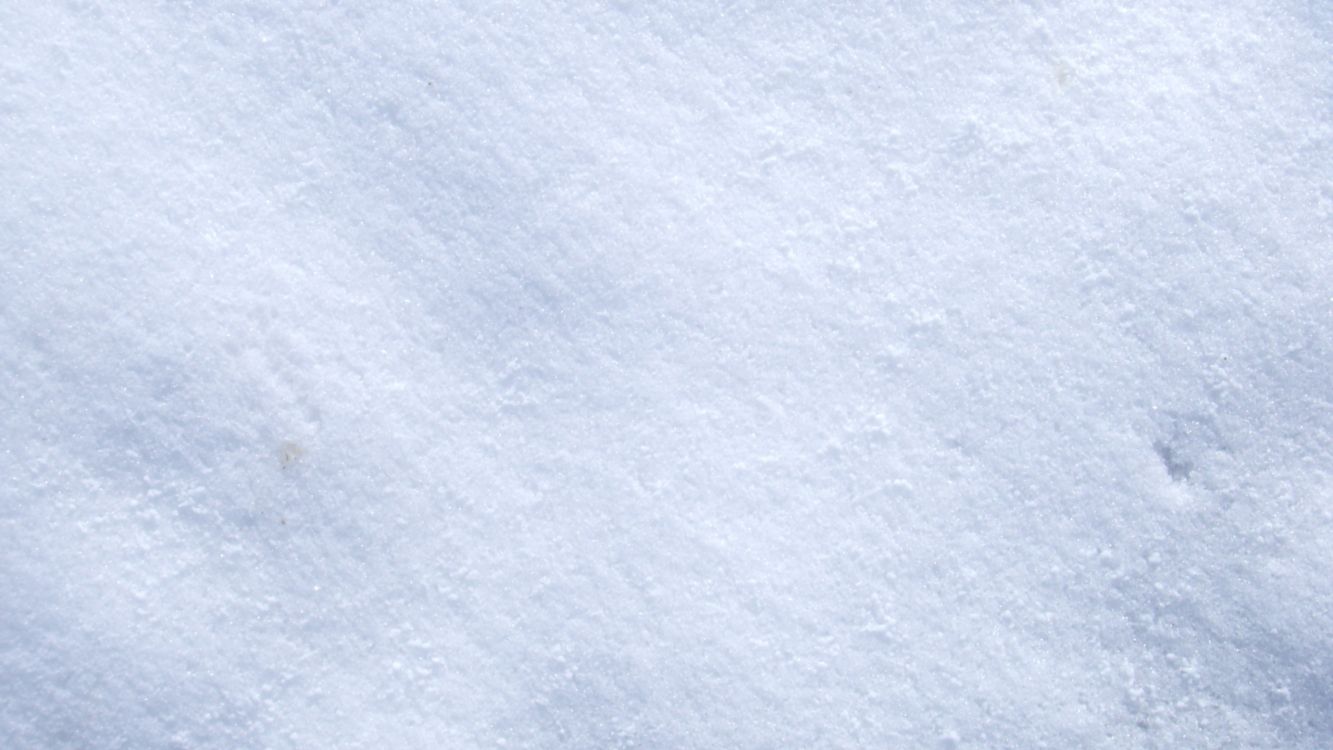 person in black shoes standing on snow covered ground