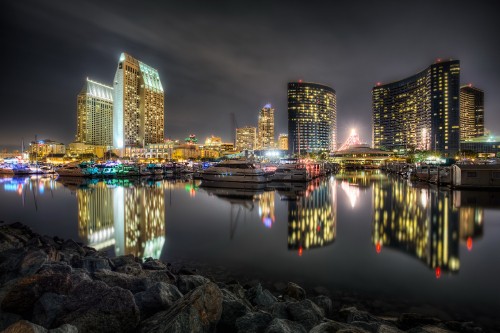 Image city skyline across body of water during night time