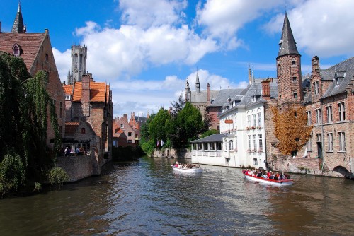 Image white boat on river near brown concrete building under blue sky during daytime