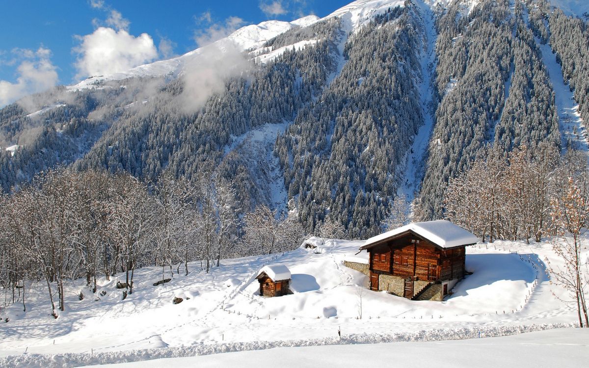 Braunes Holzhaus Auf Schneebedecktem Boden in Der Nähe Von Schneebedeckten Bergen Tagsüber During. Wallpaper in 2560x1600 Resolution