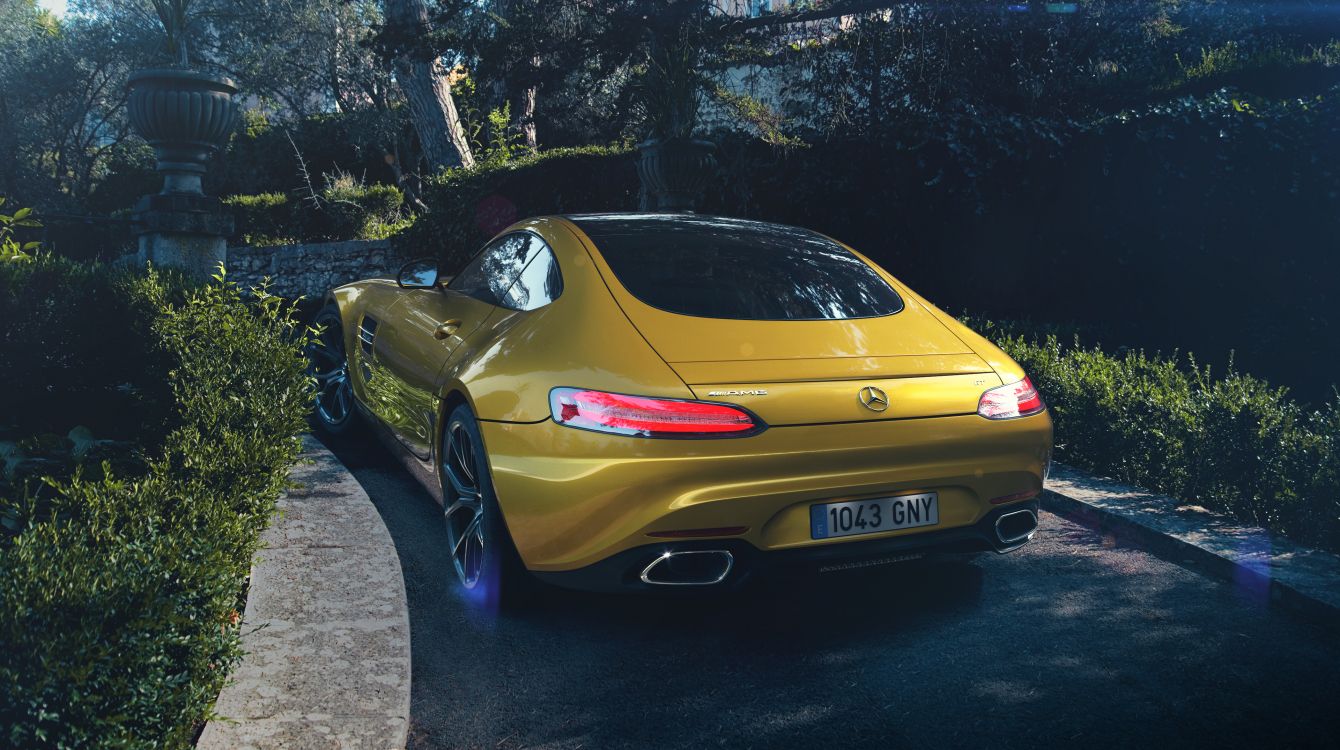 yellow porsche 911 parked on gray concrete pavement