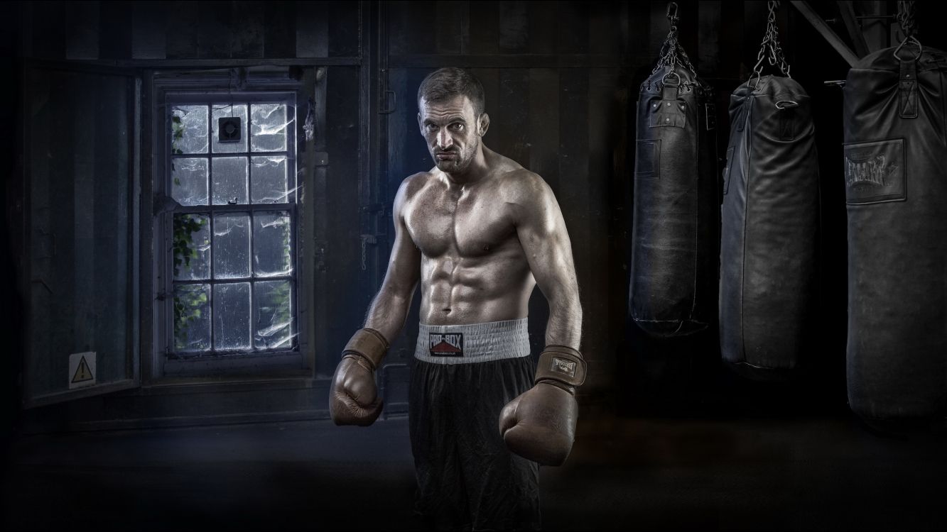 topless man in black pants and boxing gloves