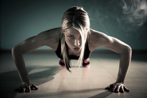 Image woman in black tank top and black pants doing yoga