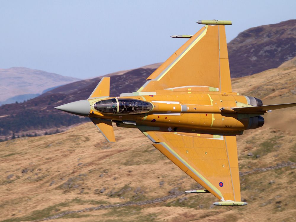 brown and black jet plane on brown field during daytime