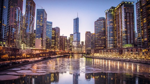 Image city skyline across body of water during night time