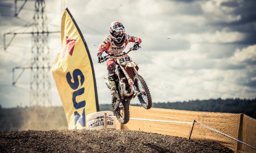 Image man in white and black racing suit riding yellow and white dirt bike