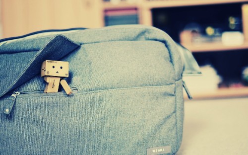 Image blue and white backpack on brown wooden table